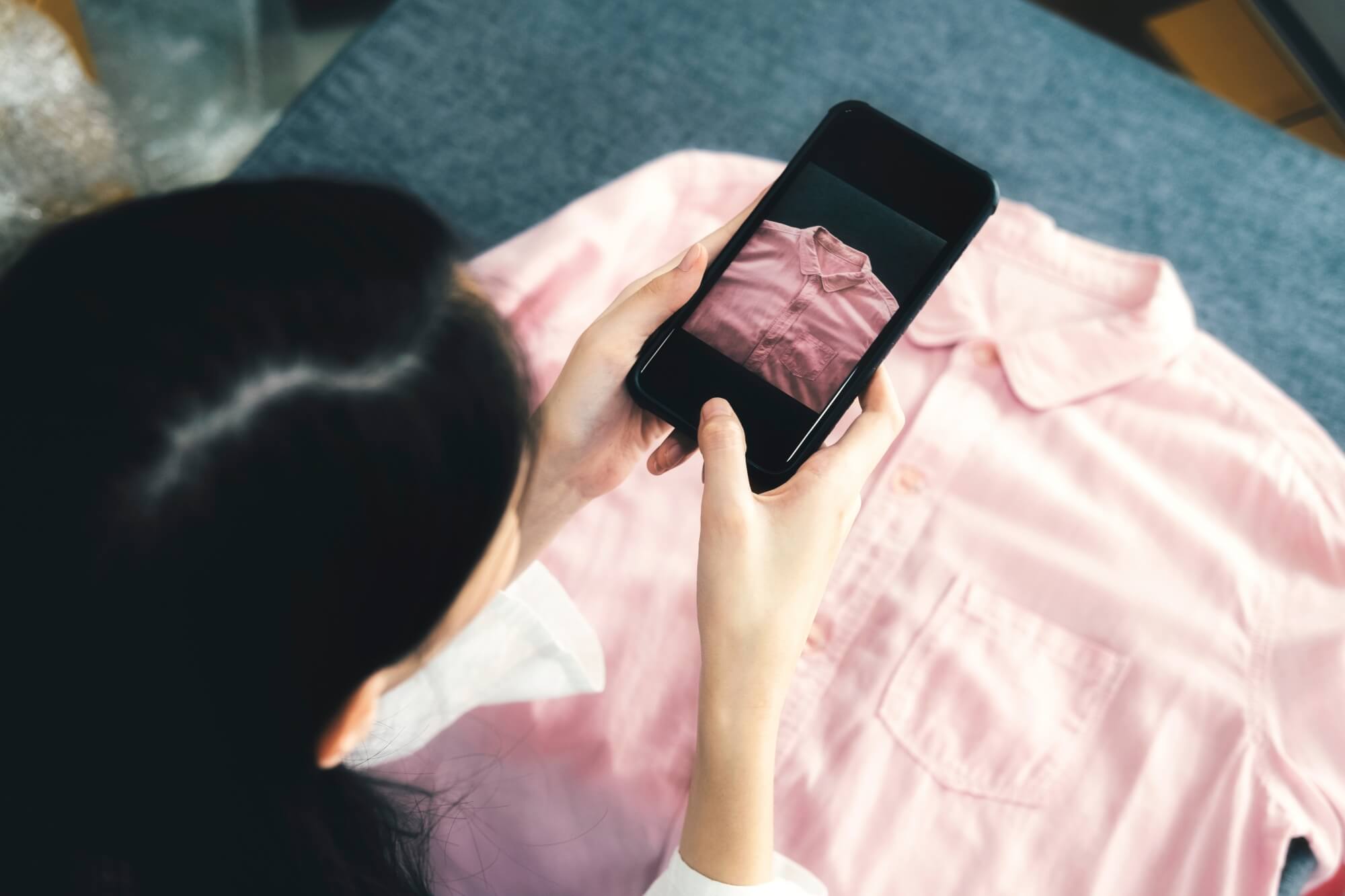 Persona tomando fotografías de un producto de moda para promocionarlo en su tienda de mercado libre