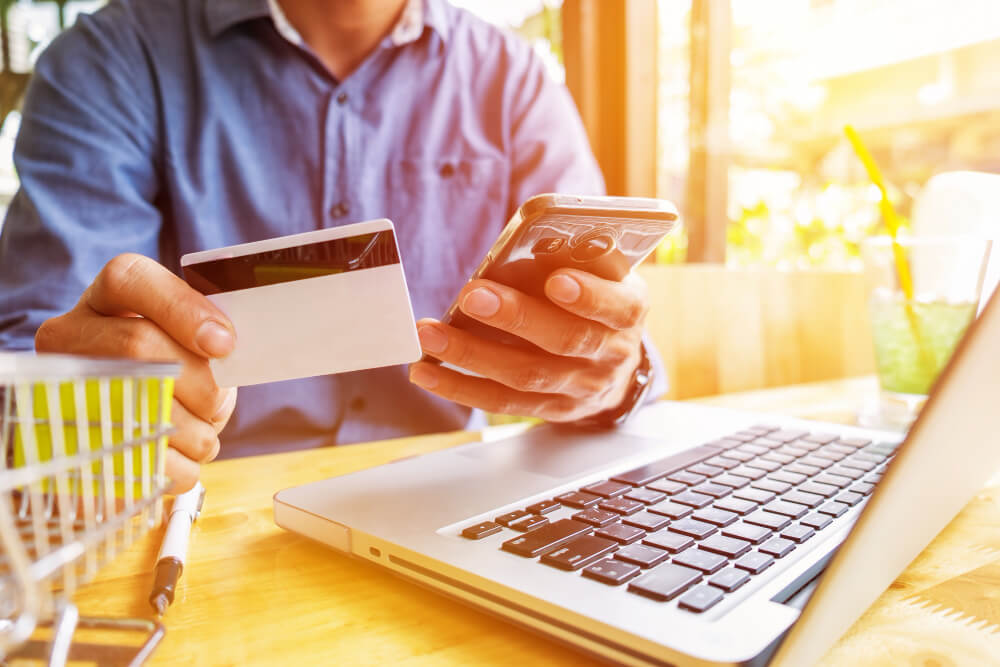 persona con un teléfono móvil y una tarjeta de crédito realizando compra en línea en un marketplace argentino